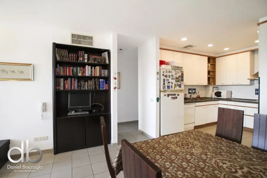 Comfortable Jerusalem real estate interior with kitchen and dining area, featuring a well-equipped kitchen and cozy living space, ideal for buyers interested in Jerusalem property listings.
