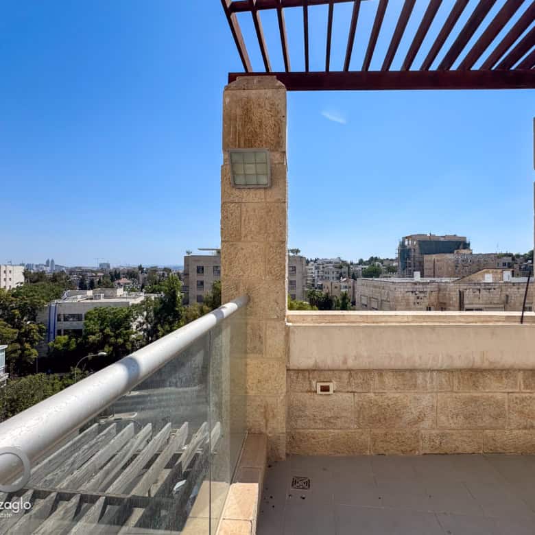 David Crown 25br furnished rental Jerusalem 13 | Daniel Bouzaglo - Jerusalem Real Estate Modern Jerusalem real estate balcony with city view, stone accents, and glass railings, perfect for upscale residential properties.