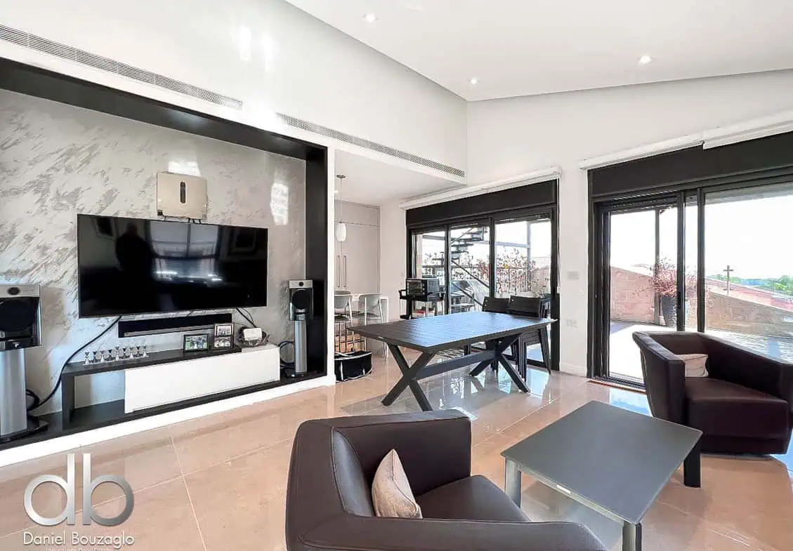 Penthouse in Talbieh with open view 27 Modern Jerusalem real estate living room with large windows, stylish furniture, and contemporary decor. Spacious interior for Jerusalem property buyers and real estate investors.