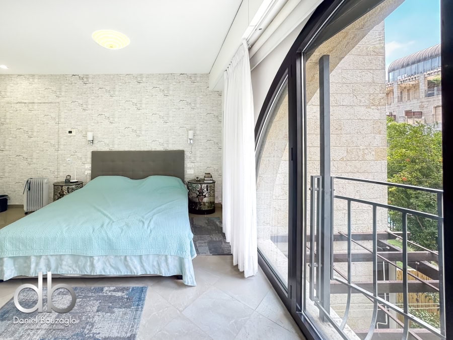 Garden apartment in David VIllage for sale 13 Modern Jerusalem real estate bedroom with balcony, contemporary design, natural light, and scenic city views. Ideal for investment or personal residence in Jerusalem.