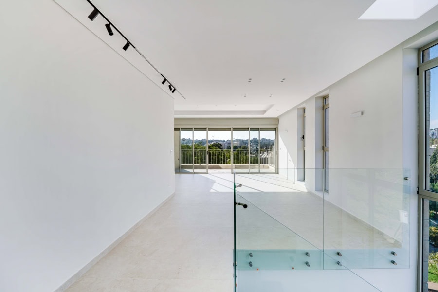 Harakevet rd duplex penthouse for sale 20_1 Modern Jerusalem real estate interior with spacious bright living area and large windows, showcasing luxury apartment design.