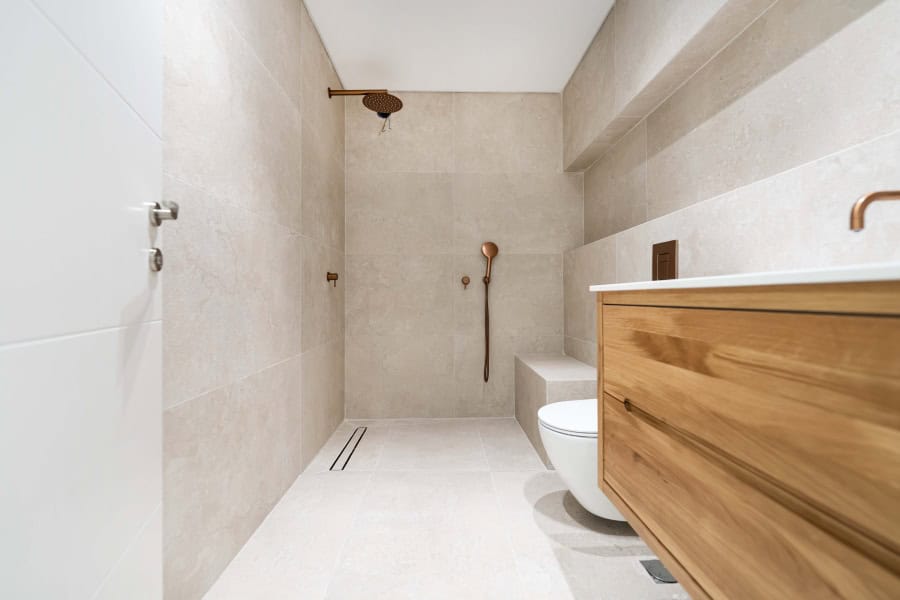 Harakevet rd duplex penthouse for sale 5_1 Contemporary Jerusalem bathroom featuring minimalist design with beige tiles, modern fixtures, and wooden accents, showcasing high-quality real estate in Jerusalem by Daniel Bouzaglo.