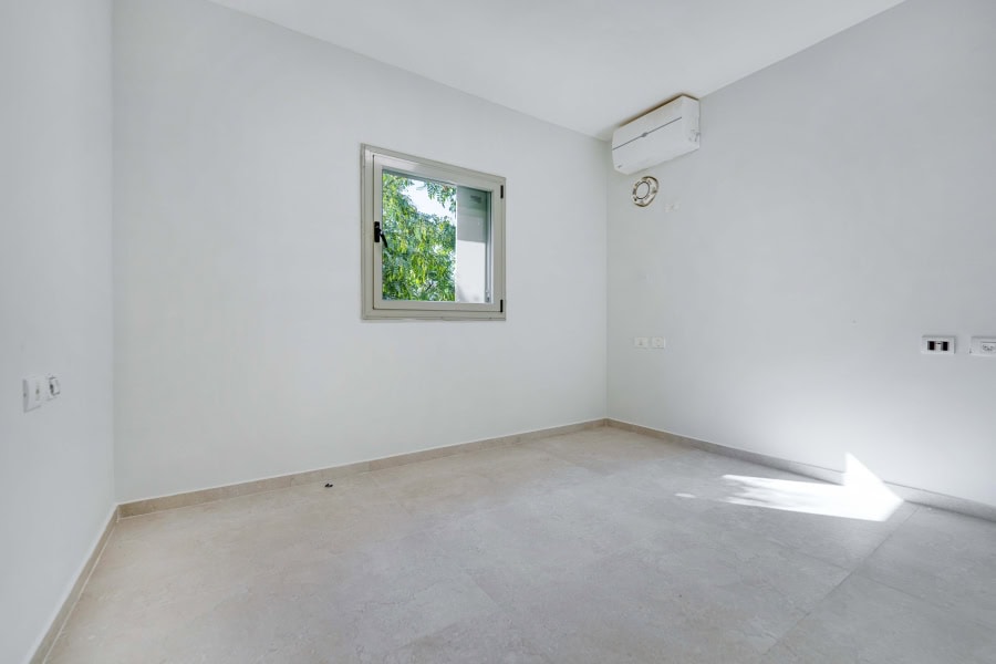 Harakevet rd duplex penthouse for sale 6_1 Modern empty room in Jerusalem real estate listing, bright space with window and air conditioning, ideal for homebuyers and investors.