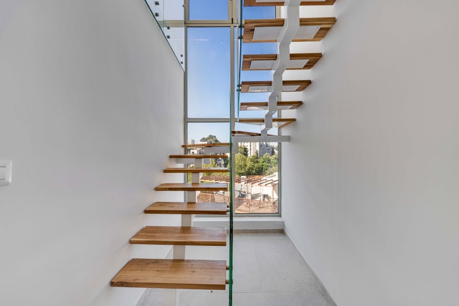 Harakevet rd duplex penthouse for sale 9_1 Modern Jerusalem real estate property featuring minimalist wooden stairs and large windows with city views, showcasing innovative architectural design by Daniel Bouzaglo.