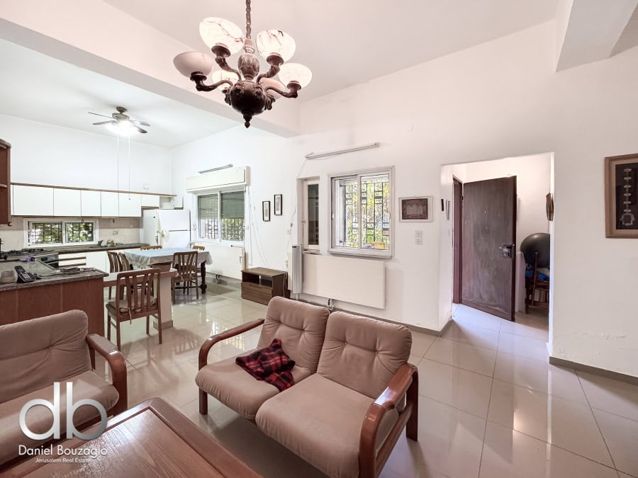 Spacious Jerusalem real estate living room with bright natural light and classic decor, ideal for buying or renting properties in Jerusalem.