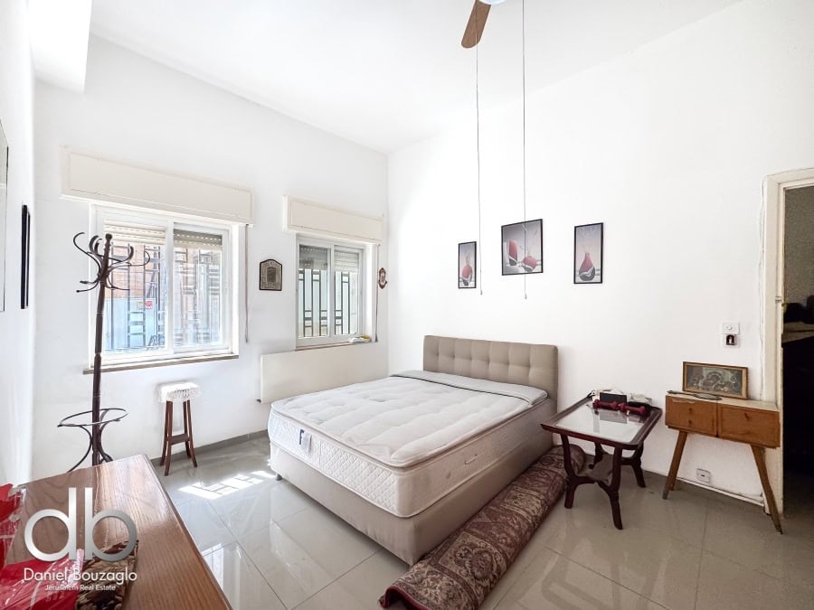 Bright bedroom in Jerusalem real estate listing with white walls, large windows, and modern decor. Perfect for buyers seeking comfortable Jerusalem homes.