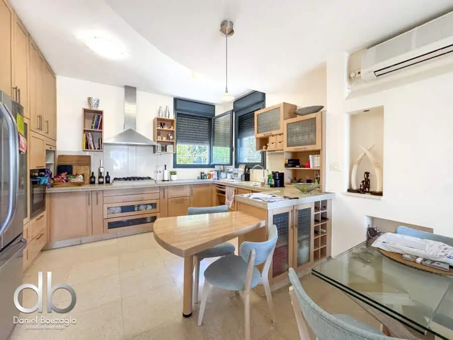 Modern Jerusalem real estate kitchen with natural wood cabinetry and contemporary appliances, ideal for buyers interested in stylish Jerusalem properties.