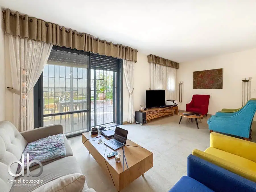 Living room with colorful furniture and balcony view in Jerusalem real estate, Daniel Bouzaglo property.