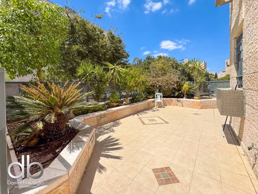 Modern Jerusalem rooftop terrace with lush greenery and spacious outdoor living area for real estate investment and luxurious lifestyle.