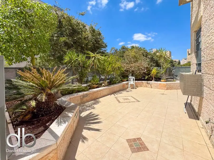 Modern Jerusalem rooftop terrace with lush greenery and spacious outdoor living area for real estate investment and luxurious lifestyle.