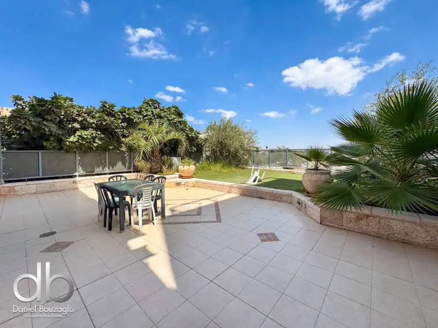 Spacious Jerusalem real estate outdoor terrace with lush greenery, stylish furniture, and panoramic city views. Perfect for relaxing or entertaining in a private, serene setting.