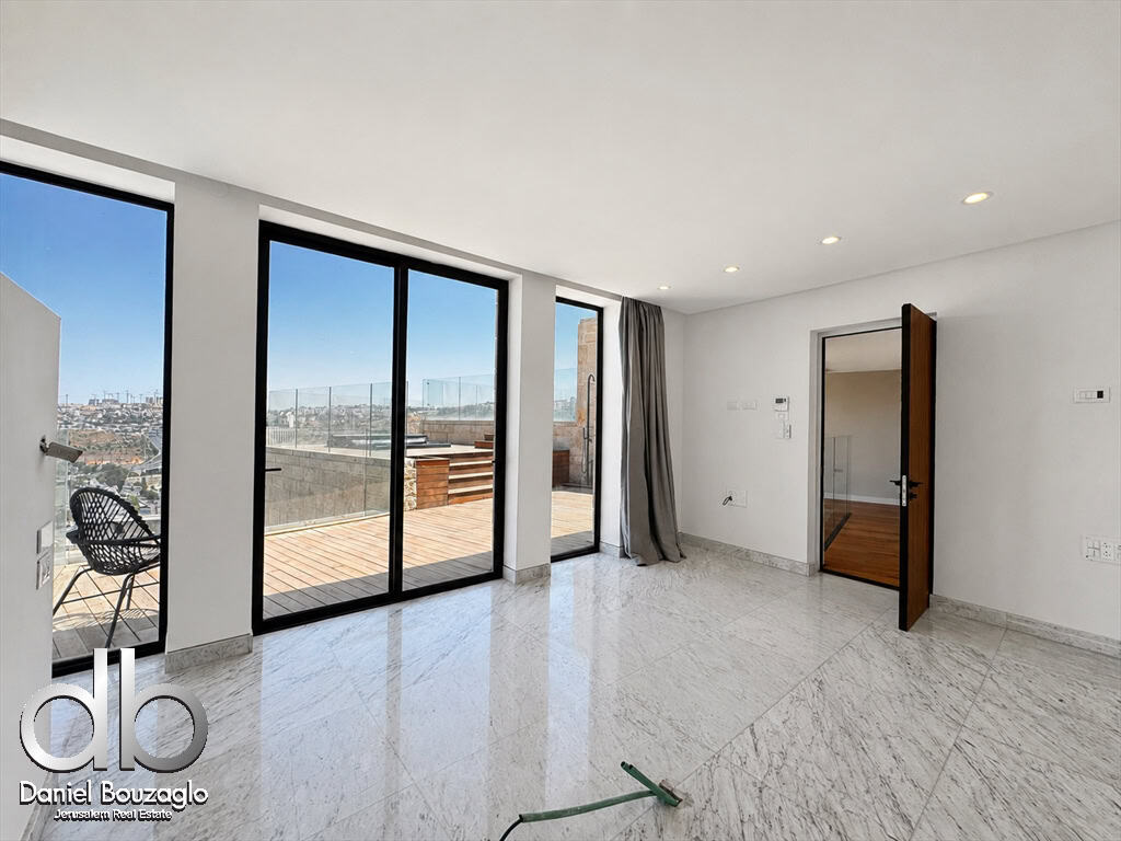 Bright living area with large floor-to-ceiling glass doors opening to a balcony and city view, marble floor.