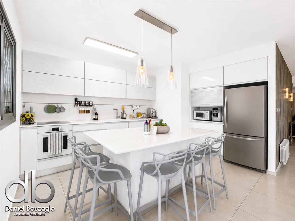 Bright, modern white kitchen with a large island and gray bar stools, stainless steel refrigerator, built-in appliances, and pendant lights overhead.